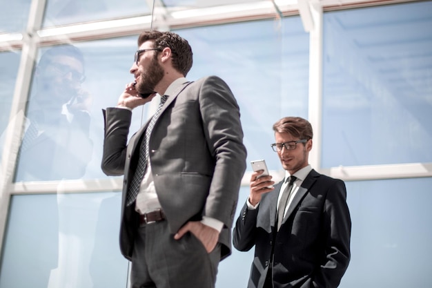 Vista lateralhombre de negocios hablando por teléfono móvil