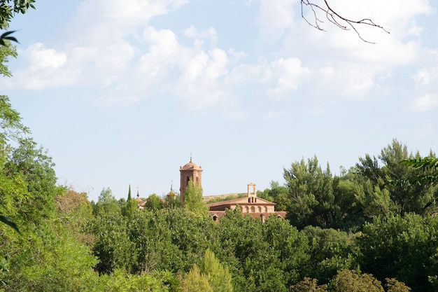 Foto vista lejana de una casa con una torre y árboles alrededor