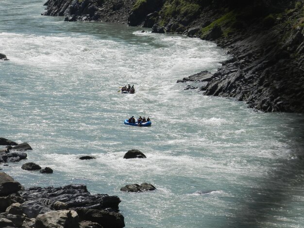 Foto vista lejana de personas haciendo rafting en el río