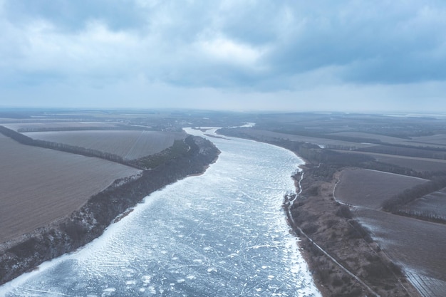 Vista desde lo alto de un río congelado en invierno heladas severas un hermoso río que se extiende en la distancia cubierto de nieve