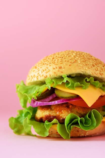 Vista macro do hamburguer saboroso com carne, queijo, alface, cebola, tomates no fundo amarelo. Feche o banner. Conceito de dieta saudável e espaço de cópia