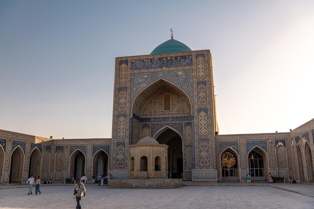 Foto vista a la madrasa mir i arab a través de una vieja puerta tallada de madera bukhara uzbekistán