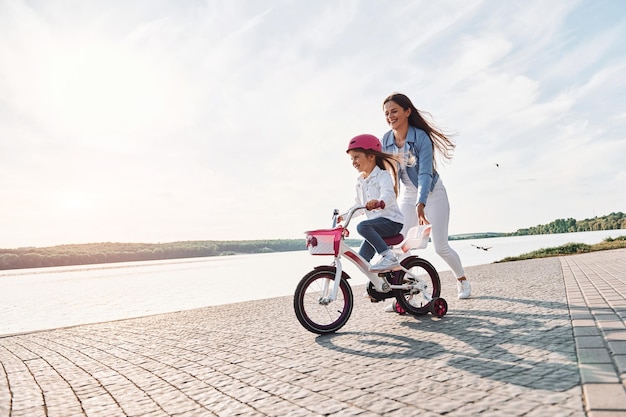 Vista majestosa do lago Mãe com sua filha está com bicicleta ao ar livre juntos