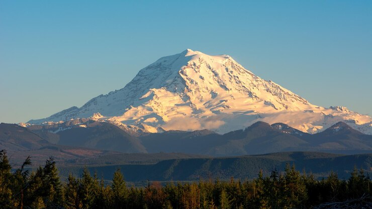 Foto vista majestuosa de la montaña cubierta de nieve contra un cielo azul claro