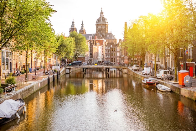 Vista de la mañana sobre el canal de agua con la iglesia de San Nicolás en Amsterdam