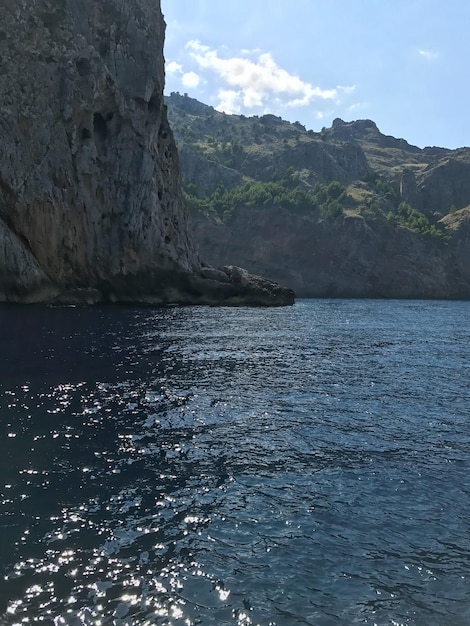 Foto vista desde el mar de las altas rocas inexpugnables de las montañas en la costa del marun mar pintoresco