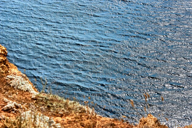 Vista del mar azul en calma desde el acantilado Enfoque selectivo en las ondas de la superficie del agua