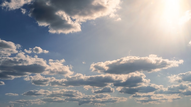 Vista maravilhosa do céu de nuvens cumulus com a luz do sol do verão. cloudscape bonito como panorama de fundo da natureza. tempo de luz natural do sol amarelo