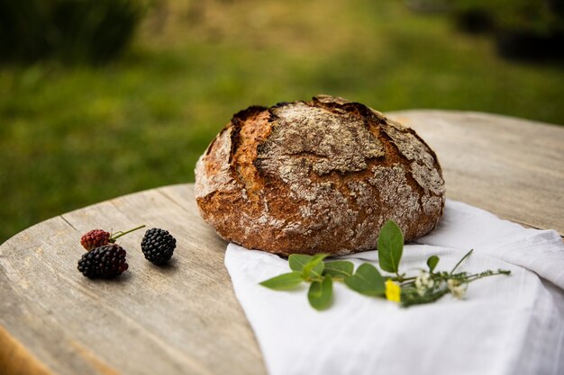 Vista de una masa de pan casero, pan rústico horneado, colocado sobre una mesa de madera. Vista horizontal.