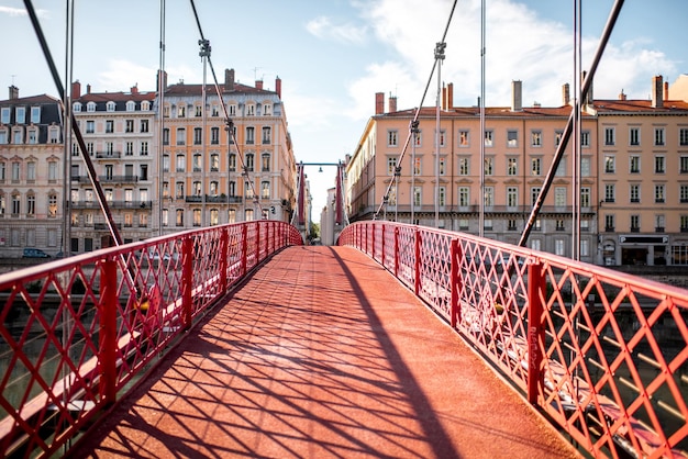 Vista matinal sobre a passarela vermelha e a margem do rio com belos edifícios na cidade de Lyon