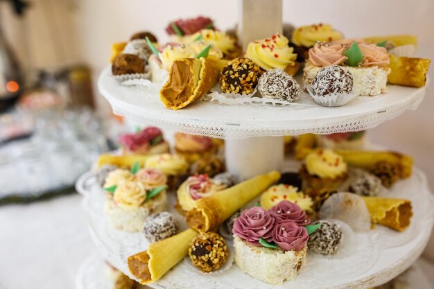 Vista de la mesa de bar de dulces servida para la cena de bodas decorada con diferentes dulces