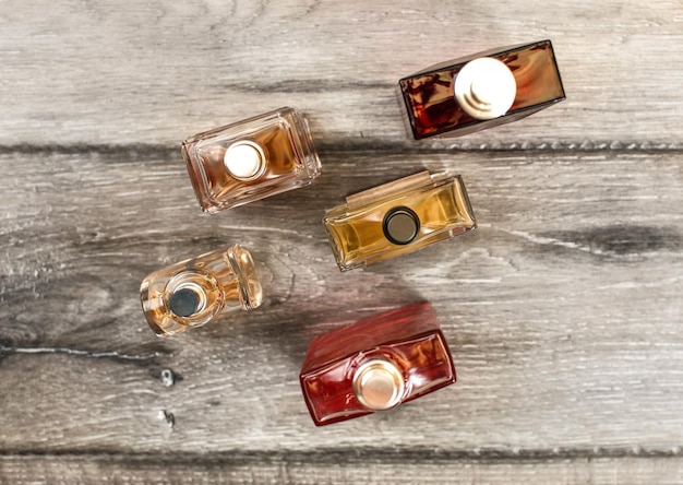 Vista de la mesa, botellas coloridas de fragancias para hombres, en el escritorio de tablas de madera.