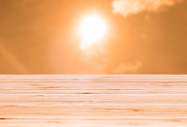 Vista de la mesa superior vacía de la plantilla con la hora del atardecer y el fondo del efecto de desenfoque del cielo amarillo