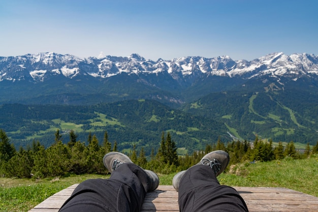 Vista desde una montaña en los Alpes sentada en un banco con los pies en la foto