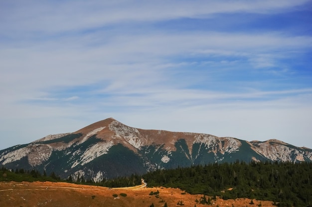 Vista a una montaña alta con una casa en la cumbre