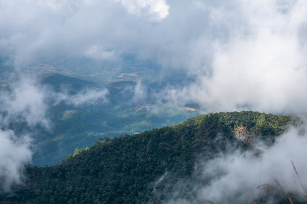 Vista de la montaña por la mañana brumosa y ver la luz del sol en la cima de la montaña.