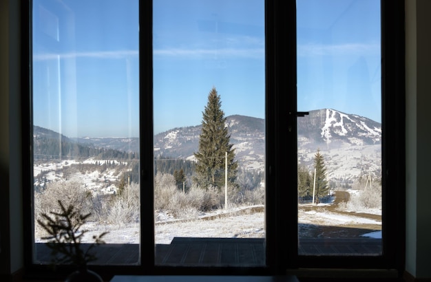 Foto vista de la montaña nevada de los cárpatos desde una ventana grande en ucrania