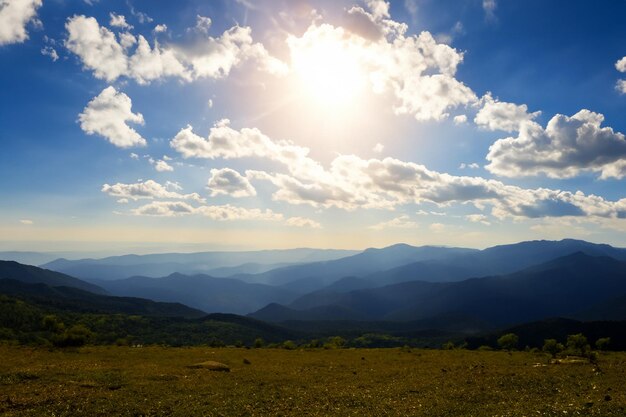 Foto vista de la montaña con sol y nubes de fondo