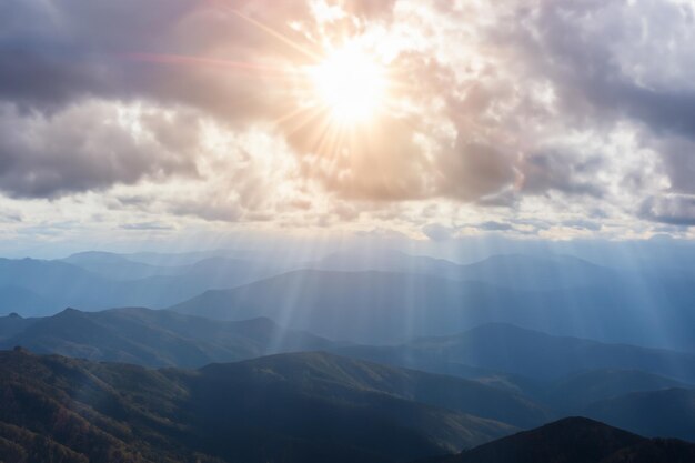 Foto vista de la montaña con sol y nubes de fondo