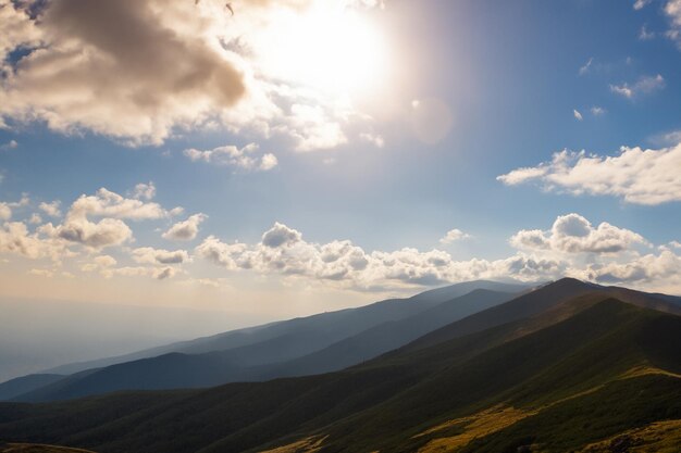 Foto vista de la montaña con sol y nubes de fondo