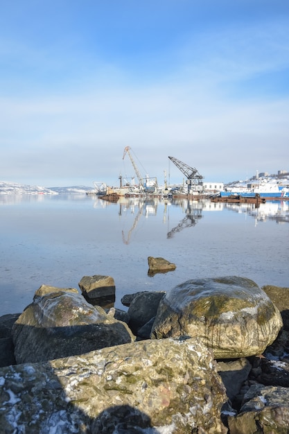 Vista de los muelles en invierno desde el mar. piedras en primer plano.