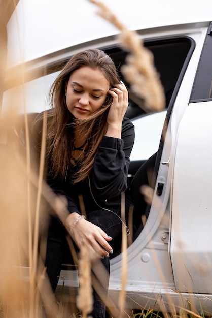 Vista de una mujer joven sentada en el coche