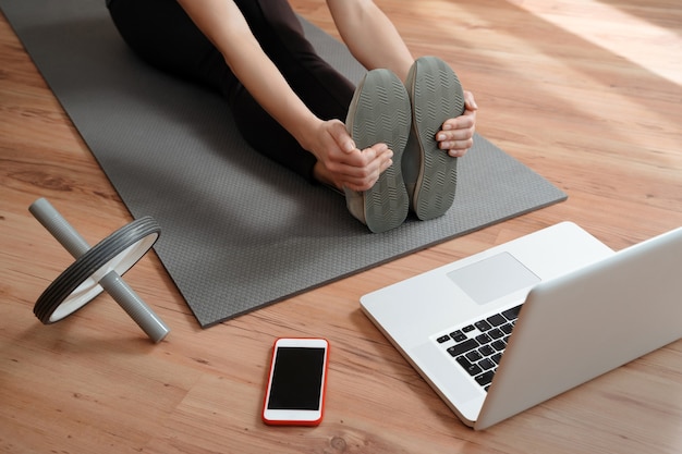 Vista de una mujer que realiza una clase de fitness virtual en casa en una videoconferencia