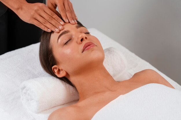 Vista de mujer recibiendo un masaje de yoga facial para mantenerse joven