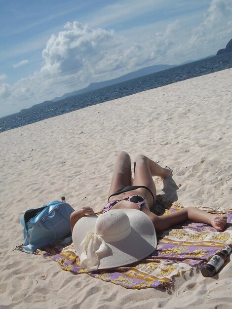 Vista de una mujer tomando el sol en la playa