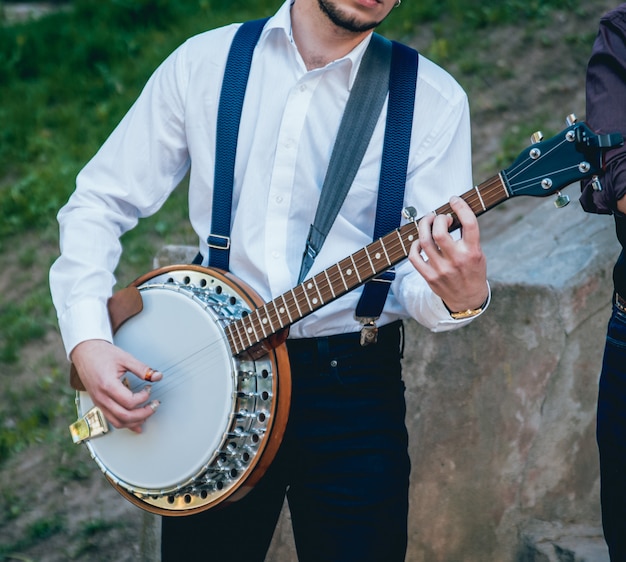 Foto vista del músico tocando el banjo en la calle