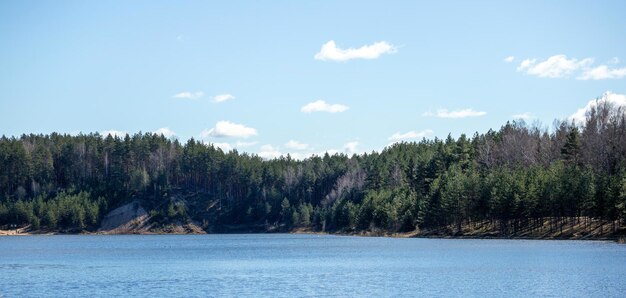 Vista de la naturaleza con lago azul árboles verdes y cielo azul