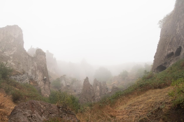 Vista de niebla en la antigua ciudad de cuevas de Khndzoresk en las rocas de la montaña Atracción del paisaje de Armenia Ruinas abandonadas en la niebla Atmosférica fotografía de archivo