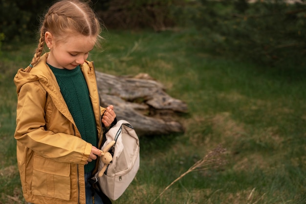 Foto vista de niña con mochila aventurándose en la naturaleza