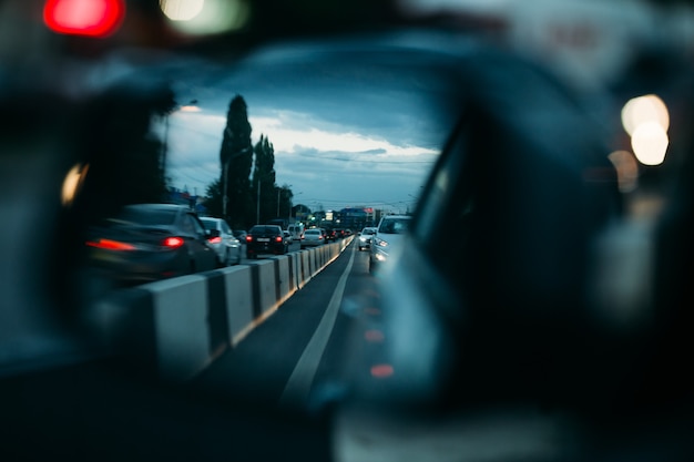 Vista no espelho retrovisor do carro, parado em um engarrafamento. Tráfego congestionado.