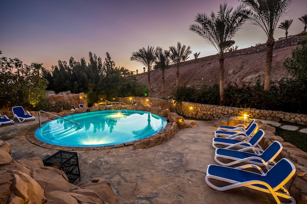 Vista de noche para piscina de lujo con iluminación nocturna