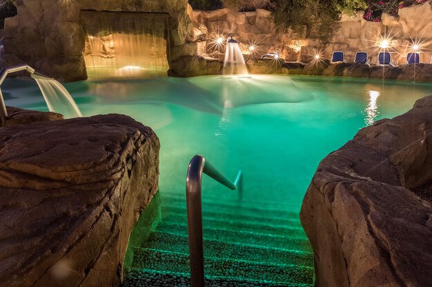 Vista de noche para piscina de lujo con iluminación nocturna