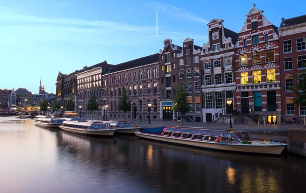 Vista nocturna de la ciudad del canal de Amsterdam casas y barcos típicos holandeses Holanda Países Bajos