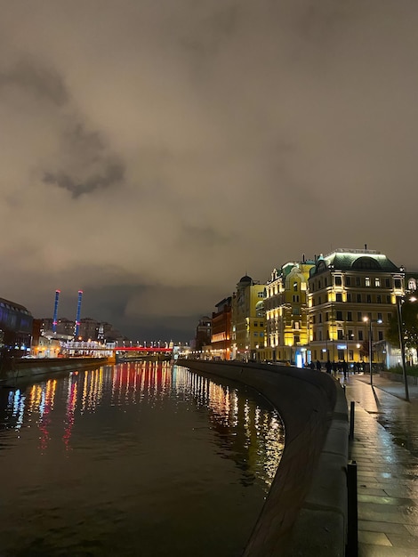 Vista nocturna de la ciudad con enfoque selectivo Las luces de neón de la ciudad se reflejan en el río por la noche