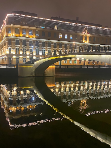 Vista nocturna de la ciudad con enfoque selectivo Las luces de neón de la ciudad se reflejan en el río por la noche