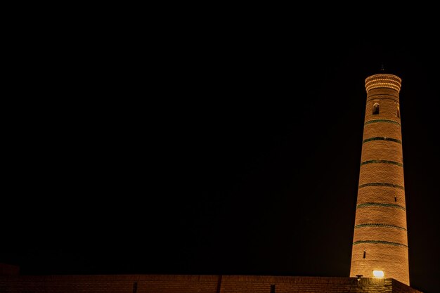 Foto vista nocturna de una estructura más alta en un color dorado khiva el oasis agrícola de khoresm ciudadela