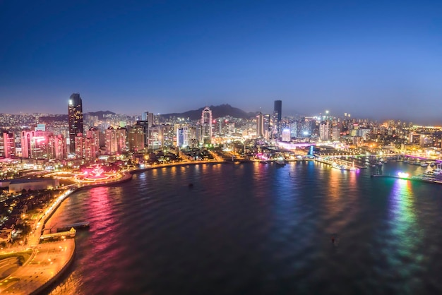 Vista nocturna de la fotografía aérea de los edificios modernos de la ciudad en Qingdao, China