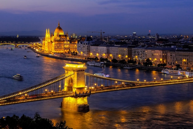 Vista nocturna del Puente de las Cadenas, el Parlamento húngaro y el río Danubio forman el Castillo de Buda