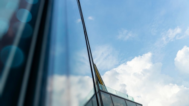 Vista de las nubes reflejadas en el fondo del edificio abstracto de la oficina de vidrio curvo