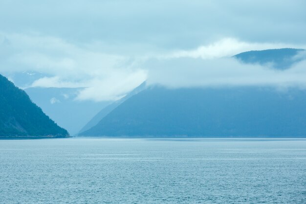 Vista nublada de verano del fiordo desde el ferry (Noruega)