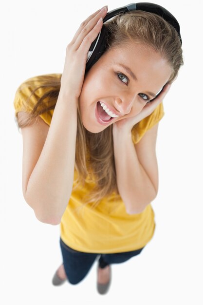 Foto vista de ojo de pez de una chica feliz usando auriculares