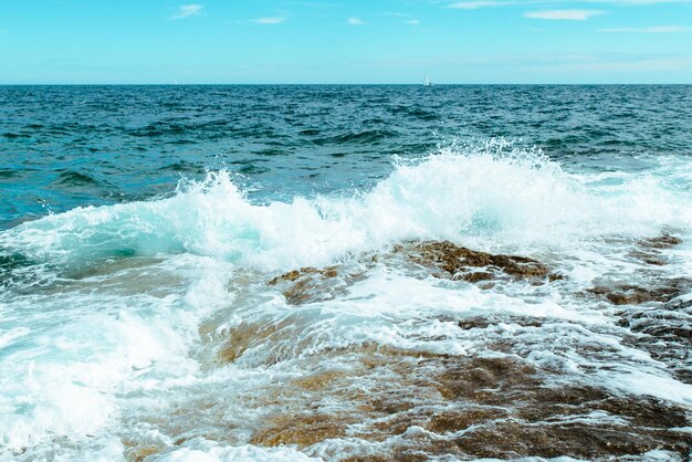 Vista de las olas rocosas junto al mar con espacio de copia de espuma blanca