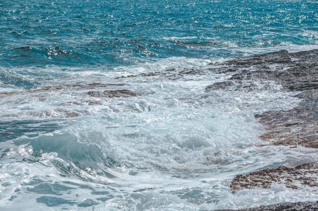 Vista de las olas rocosas junto al mar con espuma blanca