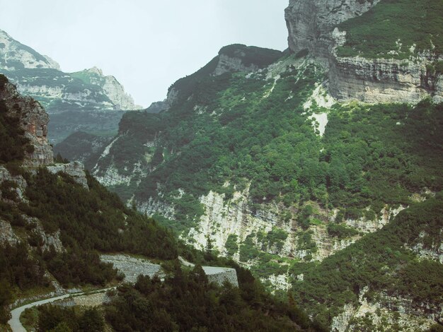 Vista de un paisaje alpino de montaña media con una carretera entre hierba y piedras en Italia