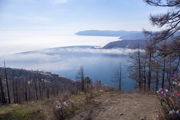 Vista del paisaje de fondo del lago Baikal con árboles y montañas en abril en Kamen Cherskogo, Óblast de Irkutsk, Rusia