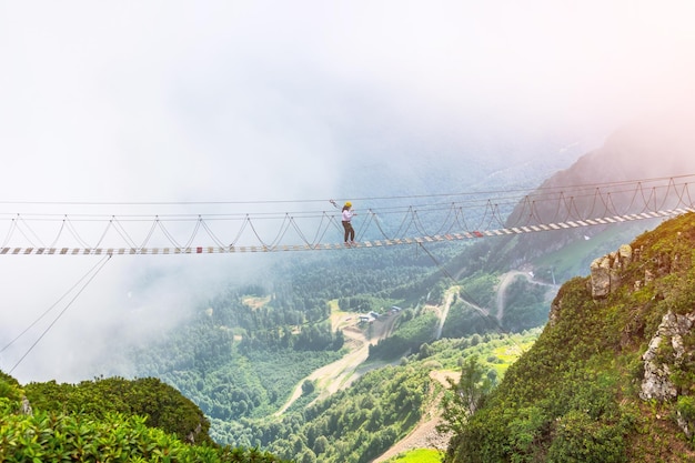 Vista del paisaje montañoso desfiladero turista humano caminando por una escalera extrema sobre un precipicio